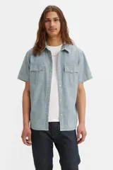 Camisa de manga corta con diseño de rayas verticales tipo railroad, cuello clásico y cierre frontal con botones. Presenta dos bolsillos en el pecho con solapa y un corte relajado.