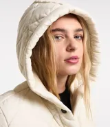 Campera de microfibra ligera color crudo, con textura capitoneada, capucha, cierre con botones a presión, mangas largas y puños con ribete en contraste.