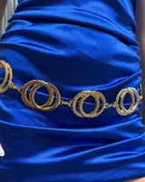 Cinturón de cadena metálica en color dorado, compuesto por eslabones circulares entrelazados con textura grabada.