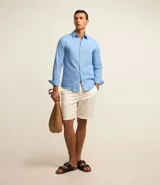 Camisa comfort masculina de lino y algodón color celeste, con cuello inglés, manga larga y abotonado delantero.