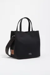 Bolso bandolera Bimba y Lola modelo Chihuahua de tamaño grande, color negro, con doble asa de mano y asa regulable de tejido. Cuenta con detalle de parche de cuero en un lateral, logo impreso en la parte inferior frontal y herrajes metálicos.