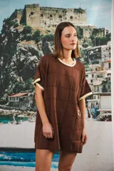 Vestido corto de tejido calado color marrón, con patrón cuadrado y logo bordado a mano en el frente. Presenta terminaciones a contratono en escote redondo y mangas cortas.