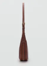Cartera de hombro tipo hobo en color marrón, confeccionada en material efecto piel. Presenta un diseño de media luna con costuras visibles en contraste, cierre superior de cremallera y asa ajustable mediante hebillas metálicas.