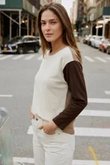 Sweater de algodón con diseño bicolor, cuerpo en color crema y mangas largas en color marrón oscuro. Presenta cuello redondo y un corte holgado tipo oversize.