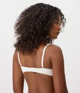 Soutien media copa de la marca Lov, color blanco, confeccionado en algodón con textura acanalada. Posee aros estructurados, detalles de delicado encaje en el escote y un pequeño moño frontal.