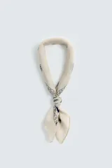 Pañuelo cuadrado de color mostaza con estampado paisley y bordes decorativos en negro.