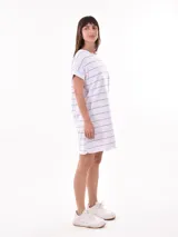 Vestido corto de manga corta, color verde militar con rayas horizontales finas en blanco. Tiene un bolsillo de parche en el pecho.