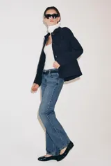 Jeans de tiro bajo y corte recto, confeccionados en denim con efecto lavado. Presentan cintura con trabillas, bolsillos delanteros y traseros, y cierre frontal con cremallera y botón.