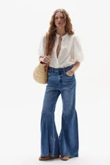 Jeans acampanados de tiro alto, color azul índigo lavado, con vuelo en el ruedo y confeccionados en denim de algodón con spandex.