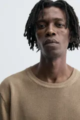 Camiseta de punto ligero color marrón topo, con cuello redondo y manga corta ancha. Presenta una textura acanalada o de estructura fina.