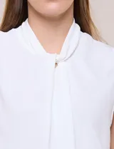 Blusa sin mangas color verde, confeccionada en crepé texturizado, con cuello alto drapeado y torsión central frontal.
