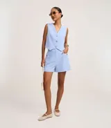 Short de sastrería color celeste, de cintura alta y corte recto. Presenta bolsillos laterales con tachuelas metalizadas, recortes delanteros con costura aparente y bolsillos traseros decorativos.