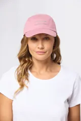 Gorro con visera de lona rosado con bordado frontal en tonos verde y violeta.