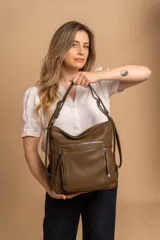 Cartera mochila versátil de cuero sintético con textura granulada, color negro. Cuenta con múltiples bolsillos frontales con cierre, correas ajustables que permiten su uso tanto como cartera de hombro o como mochila, y herrajes metálicos.