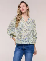Blusa holgada de gasa estampada en tonos amarillos y azules, con cuello en V, mangas 3/4 abullonadas y alforzas horizontales.