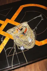 Colgante tipo pechera con múltiples cadenas doradas y plateadas, adornado con dijes de piedras naturales en tonos marrones, grises y blancos.