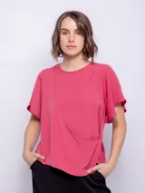 Top rosado de mangas cortas con volados, cuello redondo y detalle diagonal en el frente.