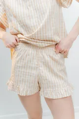 Pijama de algodón estampado Vichy, compuesto por una blusa de escote redondo y sin mangas con volados, y un short con elástico en la cintura y volados en el ruedo.