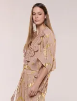Blusa holgada de gasa color rosa con estampado metalizado dorado, escote en V con pechera tejida en crochet y apliques de borlas.