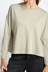 Remera color verde oliva de algodón peinado, corte oversize y mangas largas.