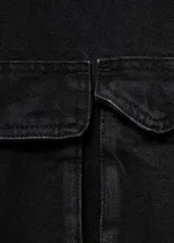 Anorak de estilo utilitario confeccionado en tejido de algodón tipo denim, con diseño oversize, cuello embudo, cierre frontal de cremallera y botones a presión, y cuatro bolsillos de parche con solapa en la parte delantera.