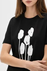 Remera de manga corta color blanco, de corte holgado con cuello redondo a la base y estampado frontal en tono bordó de un gato y un ovni en un paisaje desértico.