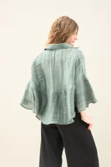 Camisa de silueta amplia y fluida color celeste, con cuello camisero clásico y mangas cortas amplias.