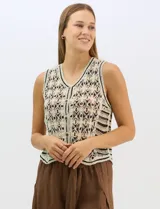 Chaleco de tejido crochet con diseño calado de motivos florales y geométricos. Presenta escote en V, cierre frontal con botones y detalles de vivos a contraste en color negro en sisas, escote y ruedo.