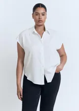 Camisa sin mangas de lyocell, color blanco, con cuello camisero y cierre frontal de botones.