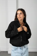 Campera corta de gamuza color marrón, con cierre frontal, cuello camisero y bolsillos frontales con solapa.