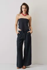 Blusa strapless azul marino de corte asimétrico con terminación en punta y flecos sutiles en el borde inferior, diseño de escote palabra de honor.