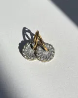 Aros de acero quirúrgico con dije circular de resina rosa y borde de strass dorados.