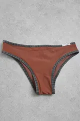 Bottom de bikini color marrón con detalles estampados a cuadros en las terminaciones y placa metálica con logo en la cintura.