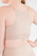 Top corrector de postura color piel, con breteles elásticos regulables, copas moldeadas en lycra y prendido frontal con ganchos.