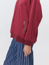 Buzo de algodón con cuello alto y cierre frontal parcial. Presenta bolsillos laterales con cierre y cuello con interior en contraste. Diseño de corte oversize.