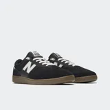 Championes New Balance modelo 508 de color negro, con detalles en blanco y suela de goma marrón. Combinan malla y gamuza, con el característico logo "N" en los laterales y cordones blancos.