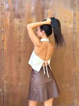 Minifalda tipo pareo confeccionada en cuero color chocolate, con diseño cruzado y cierre mediante tiritas laterales ajustables.