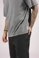 Remera de manga corta, corte oversize, color gris oscuro con efecto lavado o acid wash.