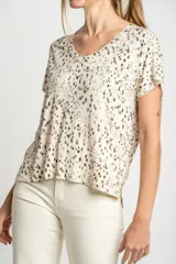 Remera color crema con estampado de manchas marrones, de corte oversize, con cuello en V y mangas cortas.