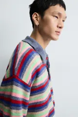 Polo de punto con diseño de rayas horizontales multicolor. Presenta cuello solapa, cierre frontal con botones y mangas largas con puños en rib.