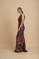 Vestido largo negro íntegramente bordado con lentejuelas en tonos fucsia y verde, con diseño floral, escote redondo y transparencias en la parte superior.