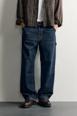 Pantalón jeans de corte relaxed fit, color celeste con efecto lavado, de estilo carpintero con bolsillos laterales y presillas de herramientas.