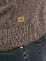 Sweater de punto color azul marino, con cuello alto, cierre frontal parcial y tapeta con botones. Presenta mangas raglán y puños y ruedo acanalados.