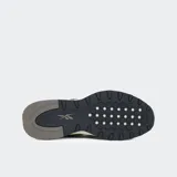 Championes Reebok Classic Leather 2400, color negro con detalles en blanco, gris y beige. Presentan el logo de Reebok en el lateral y la lengüeta, y cordones grises.