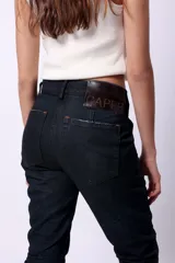 Jean de denim 100% algodón, color azul oscuro, de tiro medio y corte holgado con efecto arrugado en las piernas.