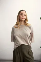 Remera color crema de corte holgado, con mangas cortas y costuras a la vista en color ocre.