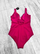 Malla entera plus size con diseño combinado, parte inferior negra y parte superior con estampado floral en tonos amarillos, rojos y celestes, con escote en V cruzado.