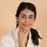 Medio aro de oro 18k con perla de cultivo colgante. Diseño minimalista y elegante.