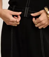 Pantalón zanahoria de crepé airflow color negro, con cintura alta, bolsillos laterales, costuras contrastantes en color blanco y cinturón elástico con hebilla metálica.