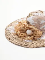 Sombrero de rafia color beige con apliques de encaje y flores de rafia.
